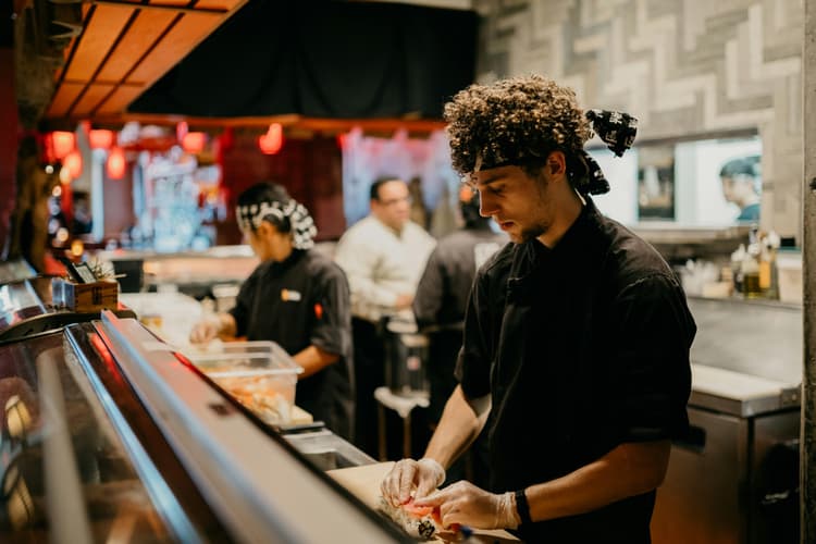 A restaurant worker rolling sushi