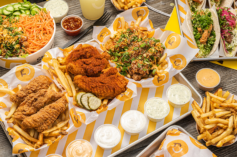A medley of fried chicken and sauces on a table.